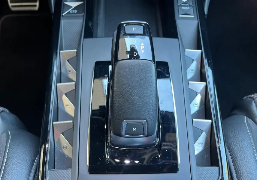 Le levier de vitesse automatique noir du DS3 Crossback Performance Line 2022 vu de dessus, entouré de boutons triangulaires.