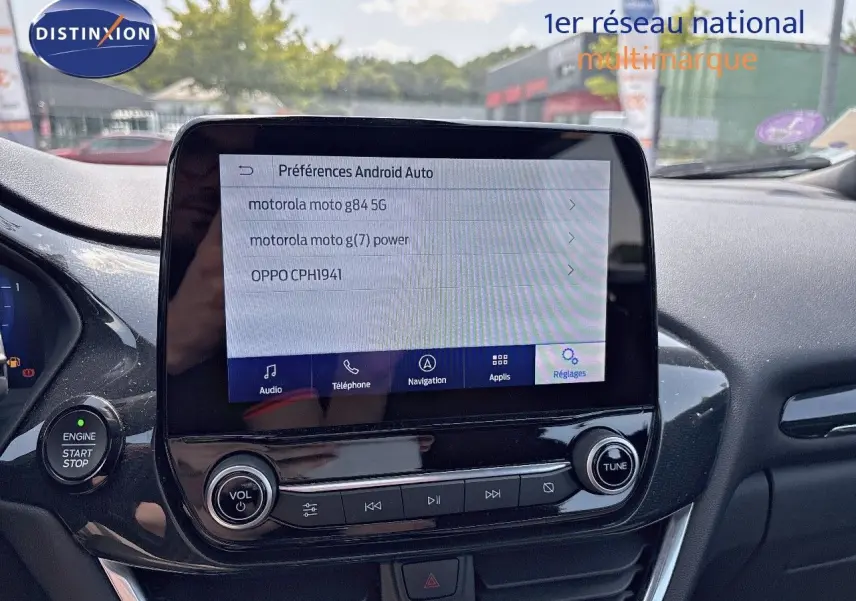 Vue rapprochée de l'écran tactile central et des commandes multimédia du tableau de bord du Ford Puma blanc 2022.