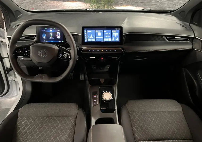Intérieur de la MG3 1.5 Hybrid+ 2024 vue de face, tableau de bord noir avec écran tactile central et volant multifonction.