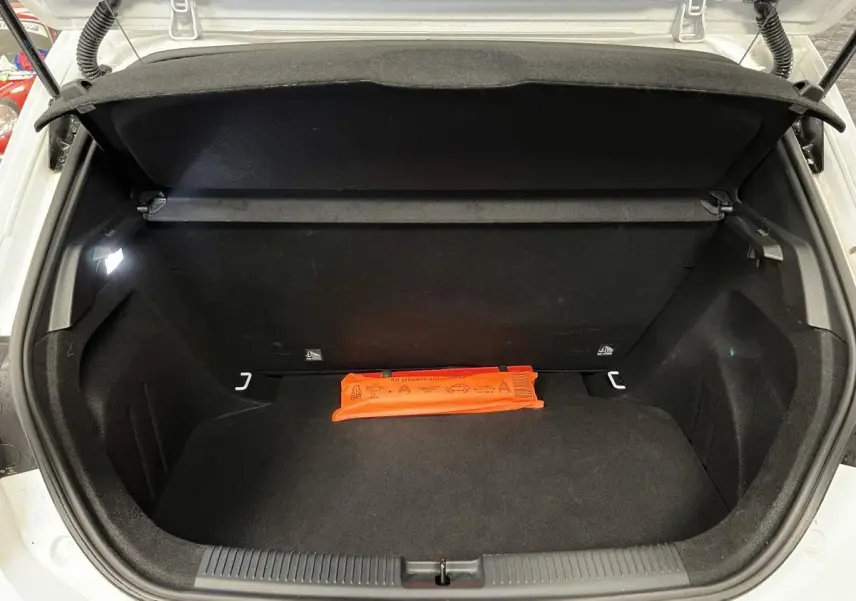 Coffre ouvert d'une MG3 blanche vue de l'arrière, avec un triangle de sécurité orange posé à l'intérieur.