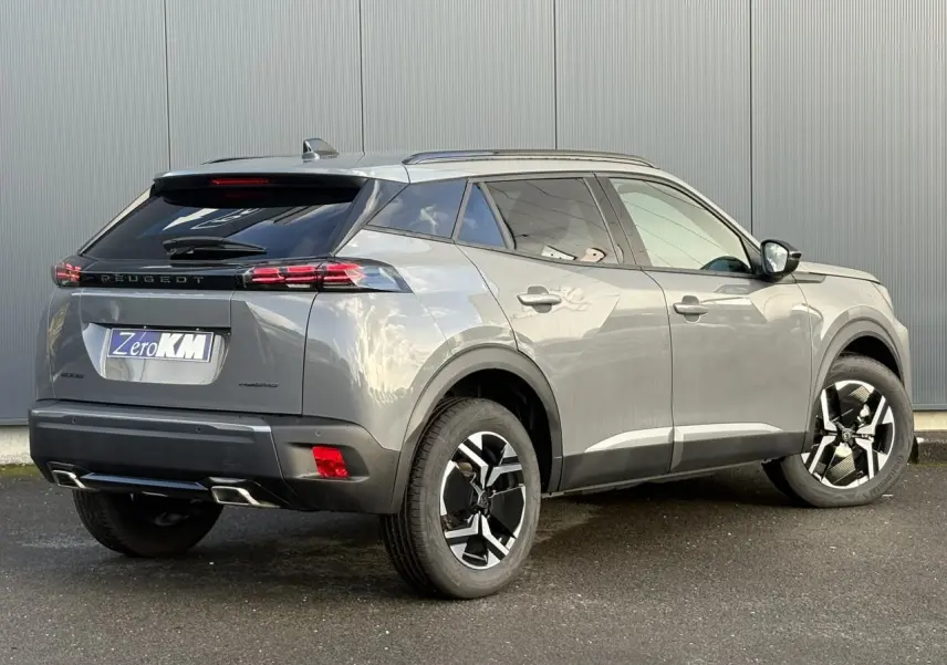 Peugeot 2008 Hybrid 145 gris Selenium en 3/4 arrière droit, jantes bi-ton et feux arrière LED 3 griffes visibles.