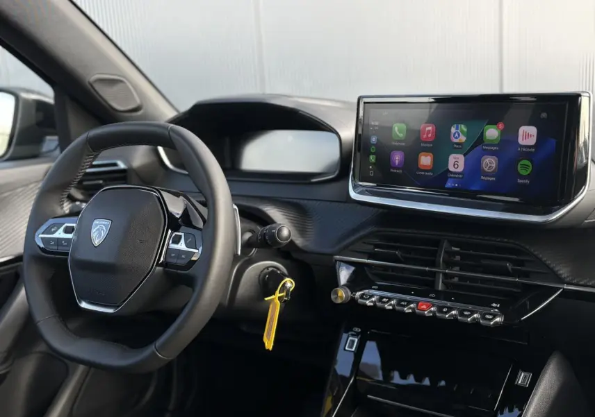 Vue intérieure du tableau de bord et volant cuir noir du Peugeot 2008 Hybrid 145 e-DSC6 Allure avec écran tactile 10 pouces.