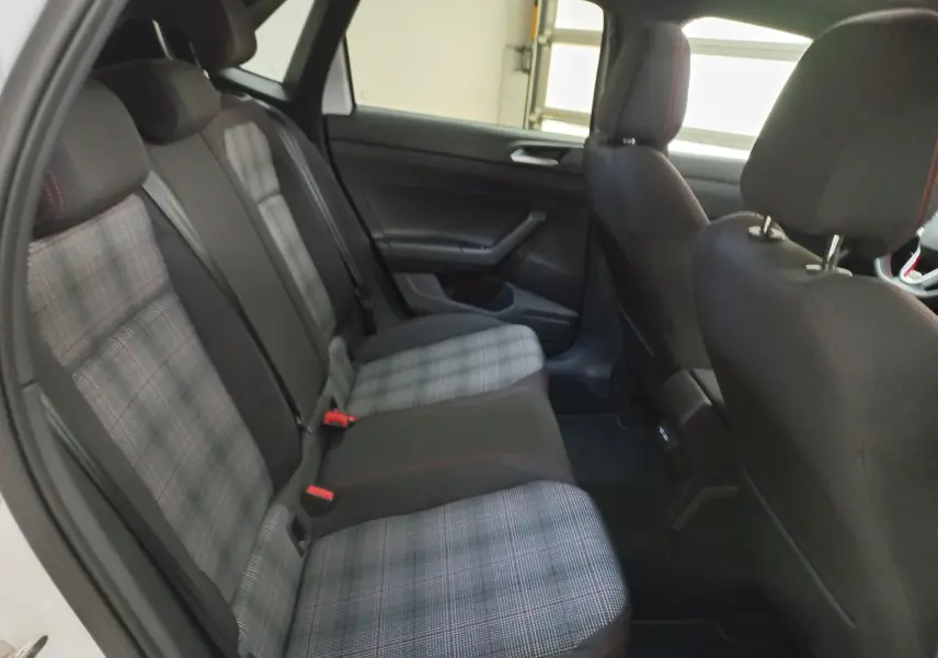 Vue intérieure arrière droite de la Volkswagen Polo 2024 avec sièges arrière en tissu à motif écossais gris et noir.