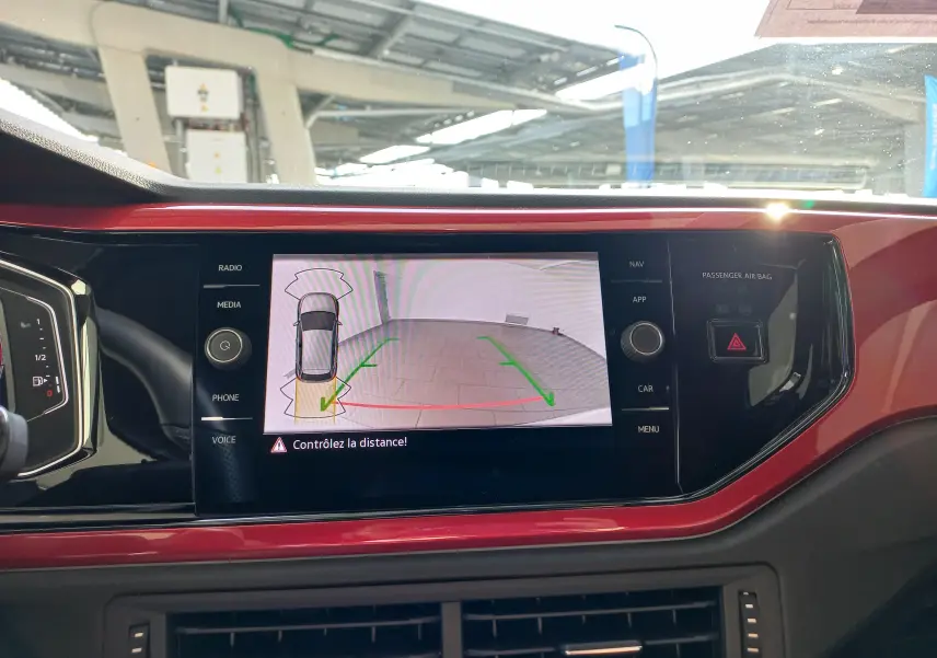 Vue intérieure sur l'écran central d'une Volkswagen Polo 2024 blanc pur toit noir, affichant la caméra de recul.