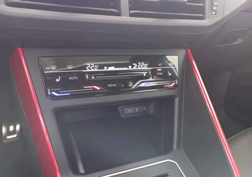 Vue rapprochée de la console centrale de la Volkswagen Polo GTI 2024, avec commandes climatisation et insertions rouges.