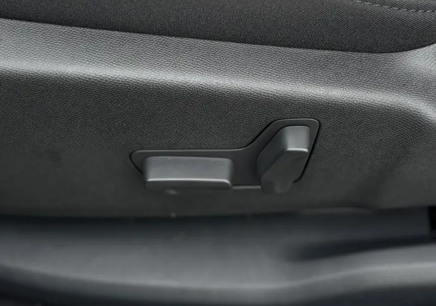 Gros plan sur les commandes électriques de réglage du siège avant noir du Citroën C5 Aircross Bleu Eclipse.