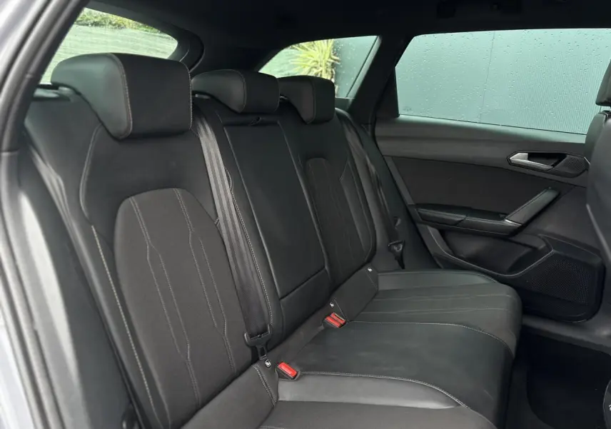 Vue intérieure côté droit des sièges arrière noirs du CUPRA LEON ST 2025 avec ceinture et garnitures en cuir et tissu.