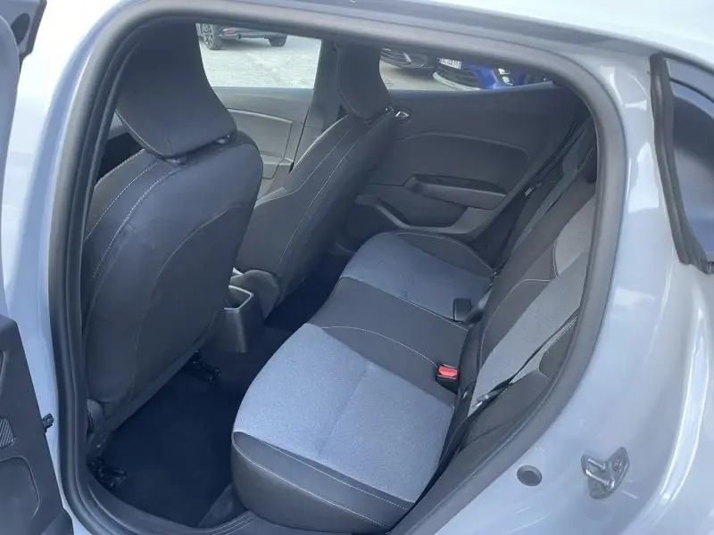 Vue intérieure arrière côté droit de la Renault Clio V DCI 100 Evolution 2025 gris métal, sièges tissu bicolore noirs et gris.