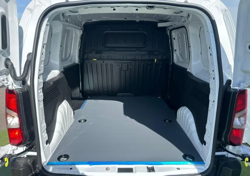 Vue arrière ouverte du Citroën Berlingo blanc Icy montrant l'espace de chargement avec plancher plat et anneaux d'arrimage.