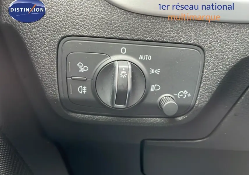 Vue rapprochée du tableau de bord noir de l'Audi Q2 2025 montrant la commande des phares et feux antibrouillard.