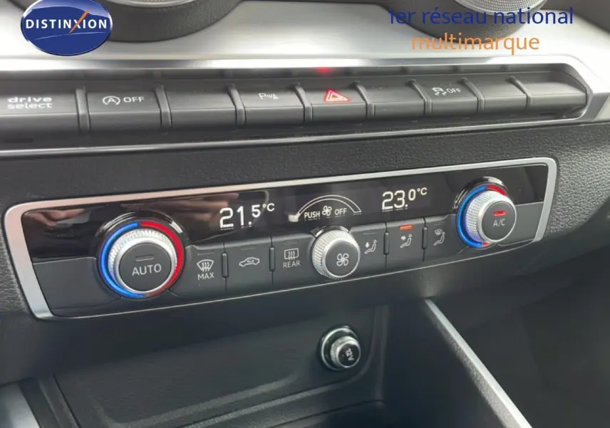 Vue rapprochée de la console centrale de l'Audi Q2 noire, mettant en valeur les commandes de climatisation digitale et boutons fonctionnels.