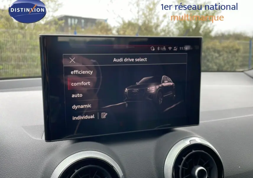 Écran central affichant les modes de conduite Audi Drive Select dans l’habitacle d’un Audi Q2 noir, vue de face.
