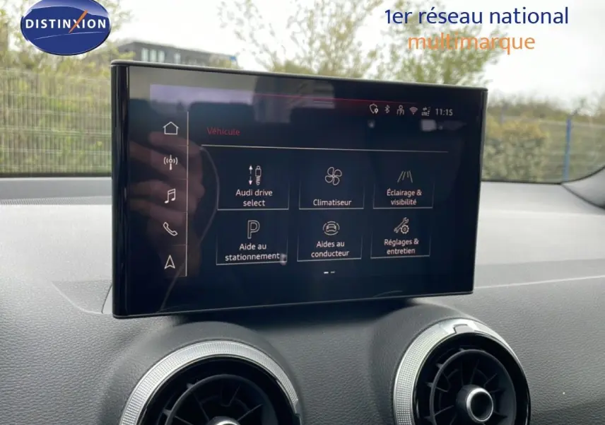 Écran tactile central affichant les options du véhicule dans l'habitacle d'un Audi Q2 noir mito metal, vue intérieure frontale.