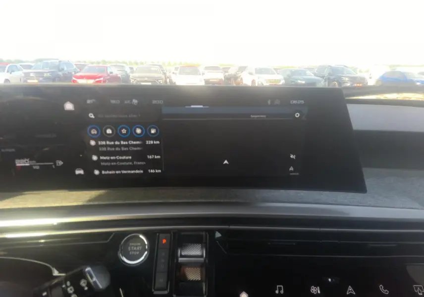 Vue intérieure du tableau de bord du Peugeot 5008 gris foncé, avec écran tactile de navigation panoramique et commandes digitales.