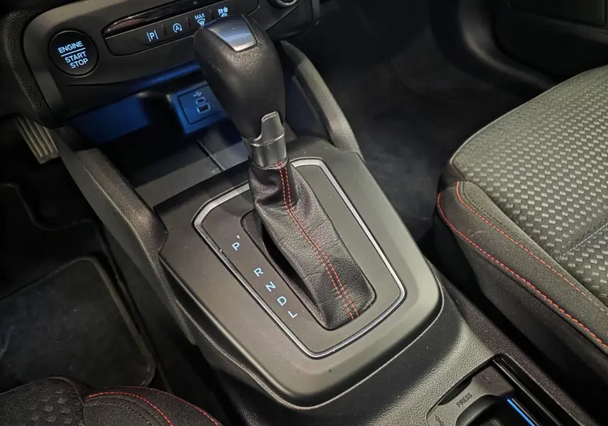 Gros plan sur le levier de vitesses automatique noir avec surpiqûres rouges dans l’habitacle de la Ford Focus ST Line 2024.