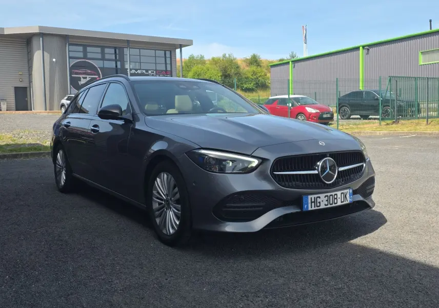 Mercedes Classe C Break gris foncé vue en 3/4 avant droit, avec jantes alliage et calandre distinctive.