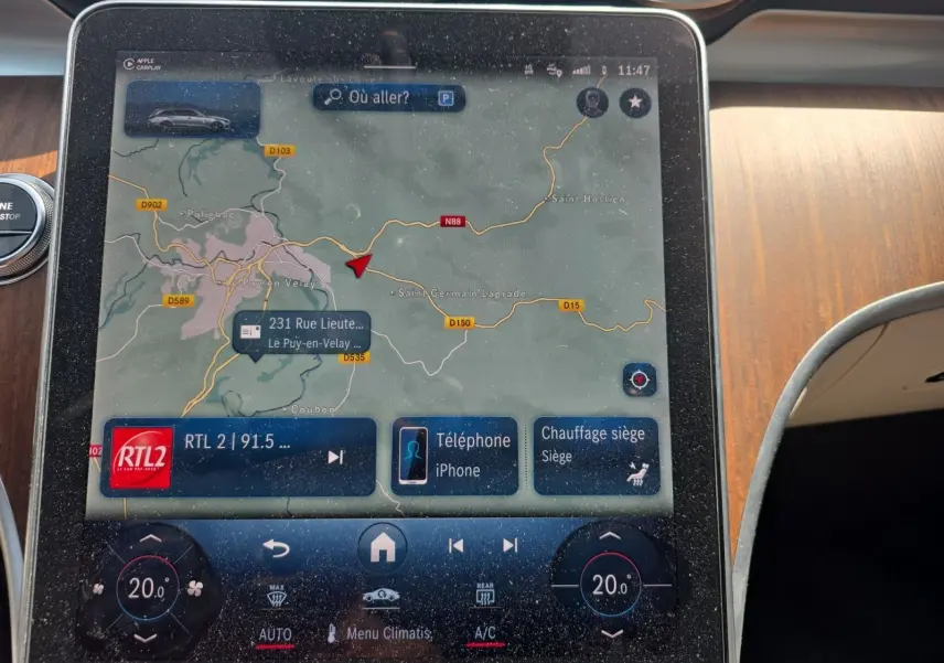 Écran tactile du système de navigation et climatisation dans le break Mercedes Classe C gris foncé, vue intérieure centrale.