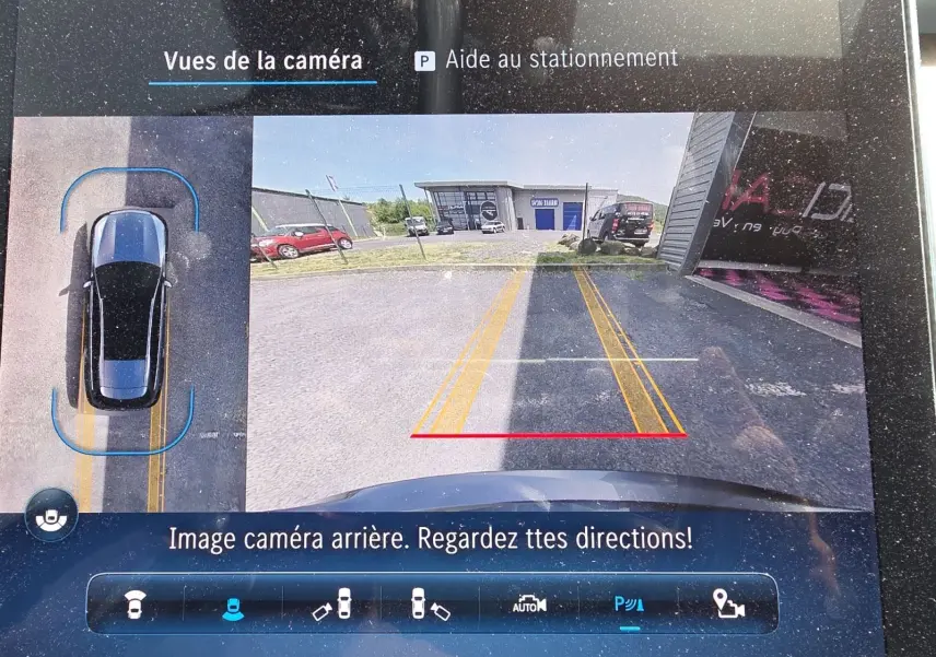 Affichage de la caméra 360° arrière d’un Mercedes Classe C Break gris foncé, avec lignes de guidage jaunes et rouges visibles.