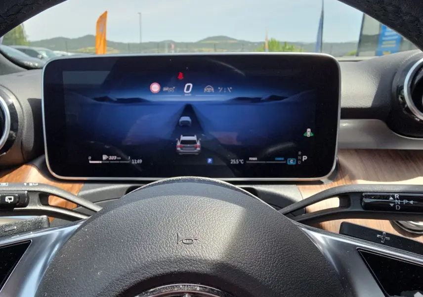 Vue intérieure centrée sur le volant et l'écran numérique du cockpit virtuel d'une Mercedes Classe C Break gris foncé.