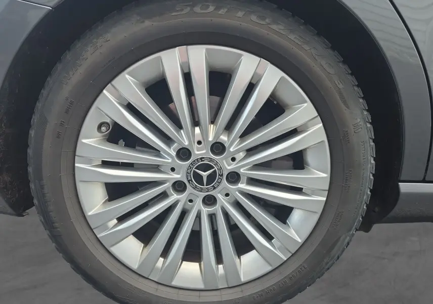 Gros plan sur la jante alliage 17” argentée d’un Mercedes Classe C Break gris foncé, mettant en valeur le logo central.