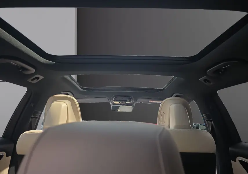 Vue intérieure arrière du break Mercedes Classe C gris foncé, avec toit ouvrant panoramique et sièges cuir beige.