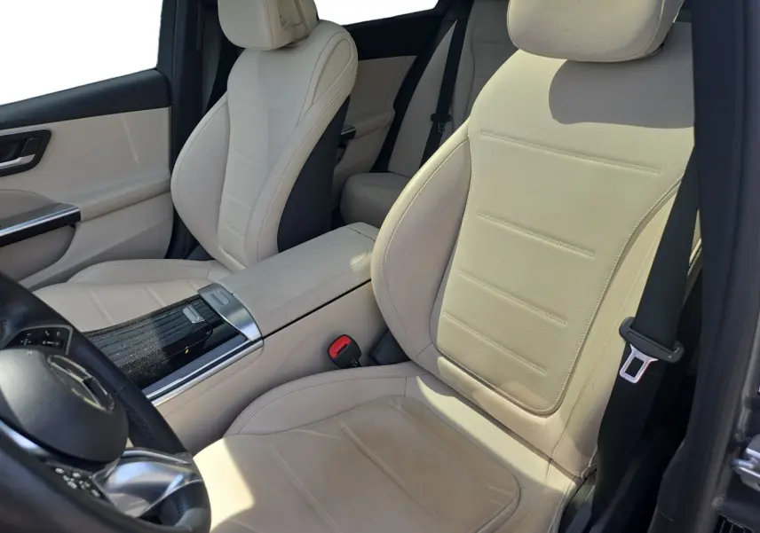 Vue intérieure côté conducteur de la Mercedes Classe C Break 220 D 4MATIC avec sellerie cuir beige et console centrale noire brillante.