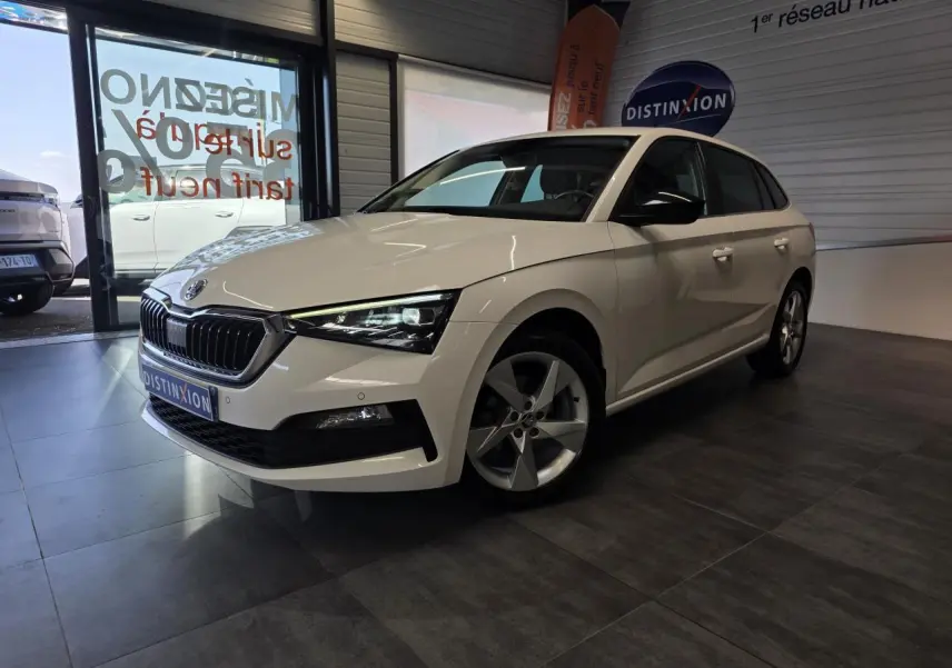 Vue 3/4 avant droite d'une Skoda Scala blanche avec jantes alliage et calandre chromée en showroom.