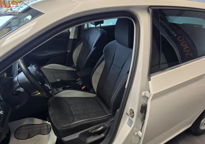 Vue intérieure côté conducteur d'une Skoda Scala blanche 2020, sièges tissu Ambition gris foncé avec surpiqûres claires.