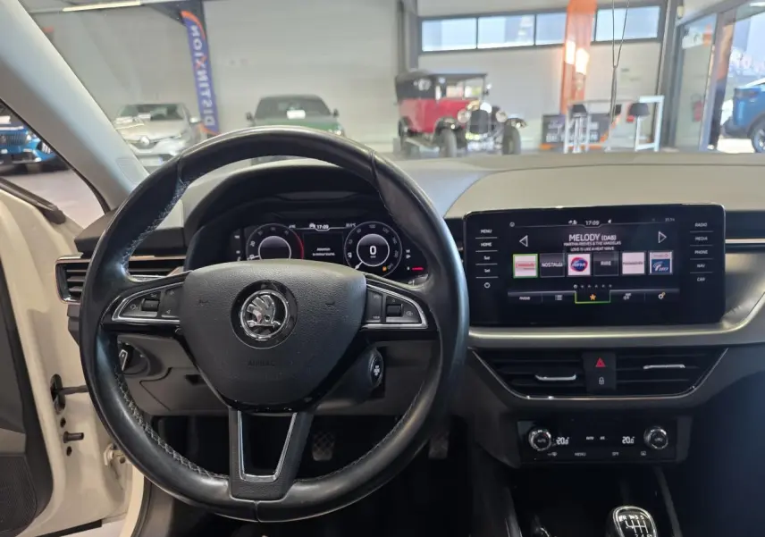 Vue intérieure centrée sur le volant cuir et le tableau de bord digital de la Skoda Scala blanche de 2020.