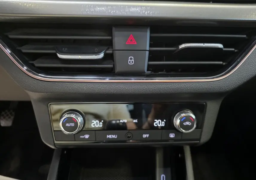Détail de la console centrale noire avec climatisation automatique bi-zone et commandes digitales sur Skoda Scala blanche.