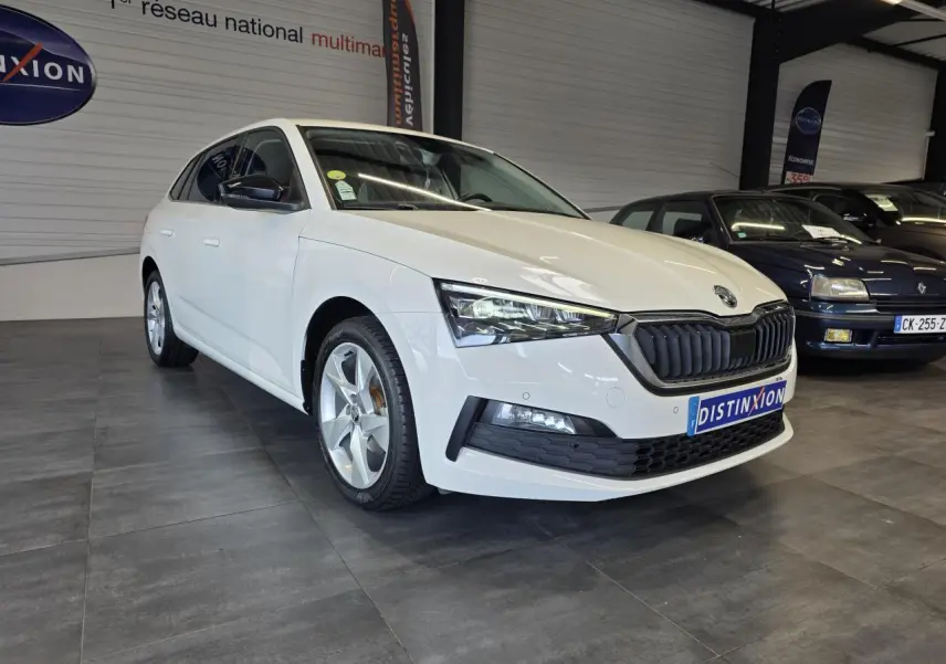 Vue 3/4 avant droite d'une Skoda Scala blanche avec calandre noire et jantes alliage argent dans un showroom.