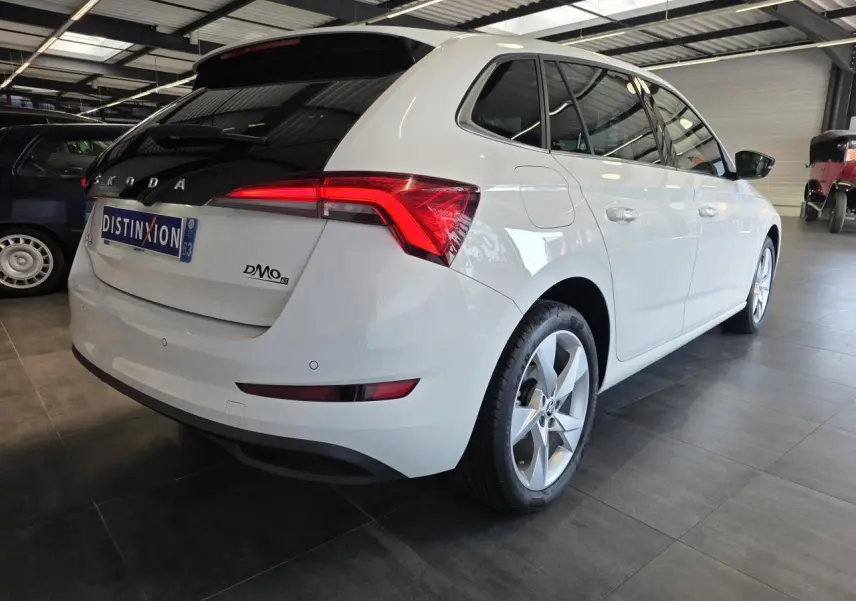 Vue 3/4 arrière droite d'une Skoda Scala blanche avec feux arrière LED et jantes alliage argent.