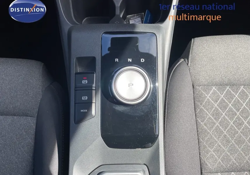Vue plongeante sur la console centrale de la MG3 2024 Pebble Black, avec molette de boîte auto et sièges tissu gris.