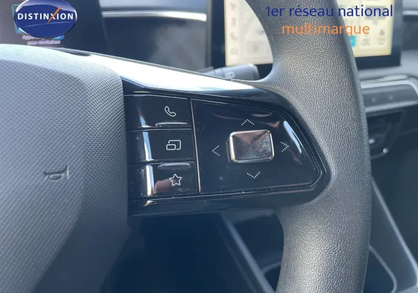 Gros plan sur les commandes gauche du volant d’une MG3 2024 en intérieur gris noir, avec boutons multifonctions.