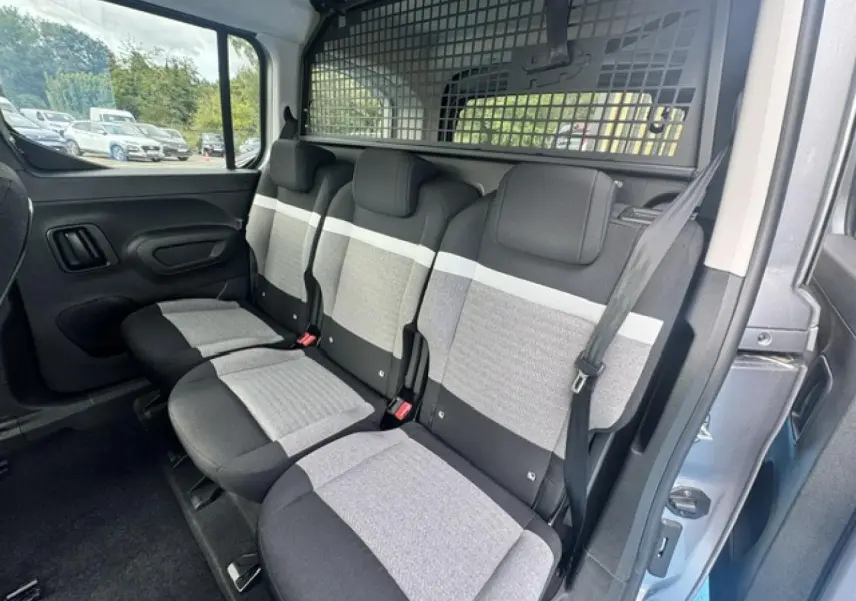 Vue intérieure côté droit des trois sièges individuels arrière gris clair et foncé du Citroën Berlingo Gris Acier 2026, avec séparation grillagée.