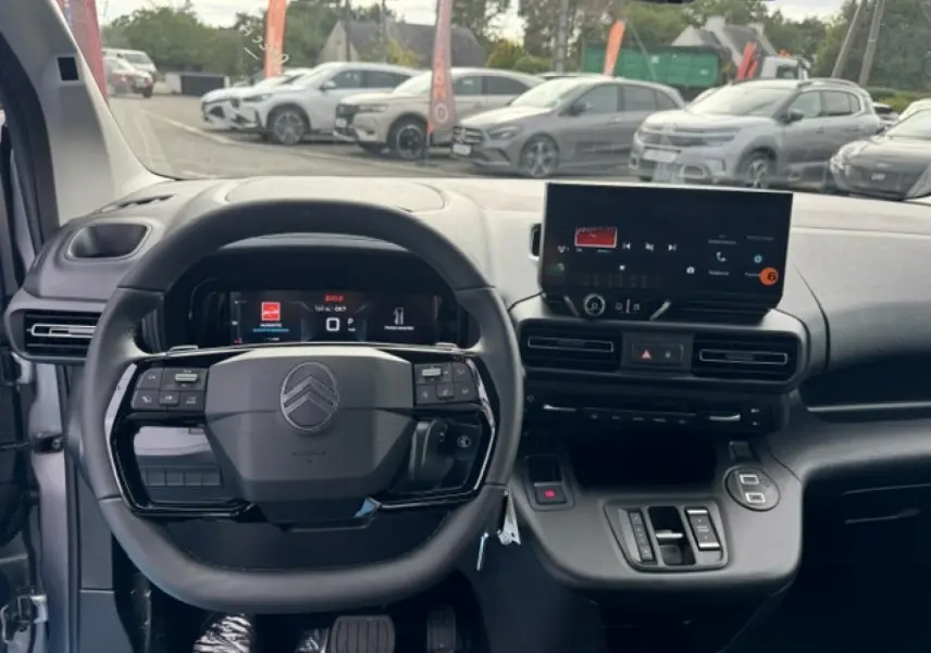 Vue intérieure frontale du tableau de bord et volant cuir noir du Citroën Berlingo gris acier 2026 avec écran tactile.