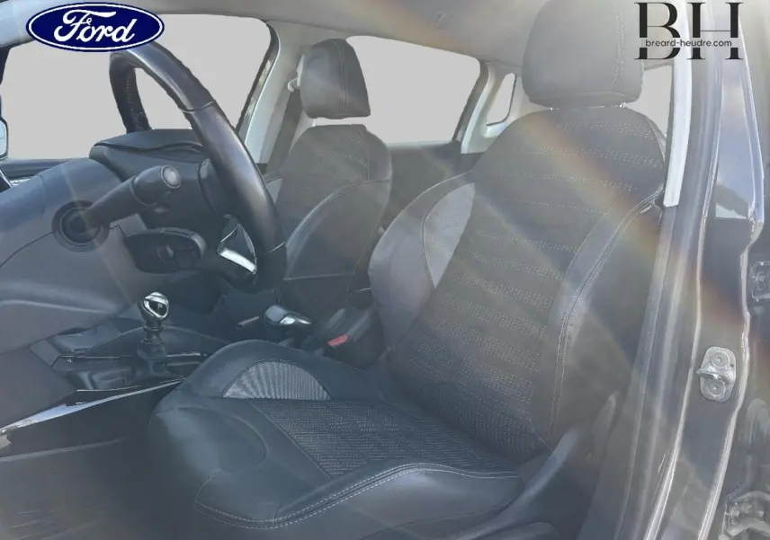 Vue intérieure côté conducteur du Peugeot 2008 1.6 BlueHDi 120ch Allure S&S 2015, sièges noirs et volant cuir multifonction.