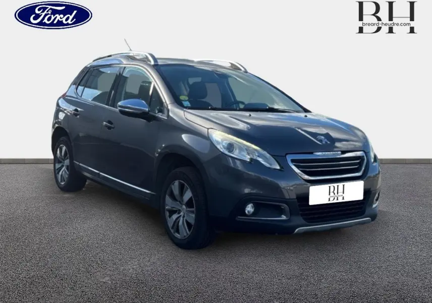 Peugeot 2008 diesel Spirit Grey en 3/4 avant droit, avec barres de toit et jantes alu visibles.