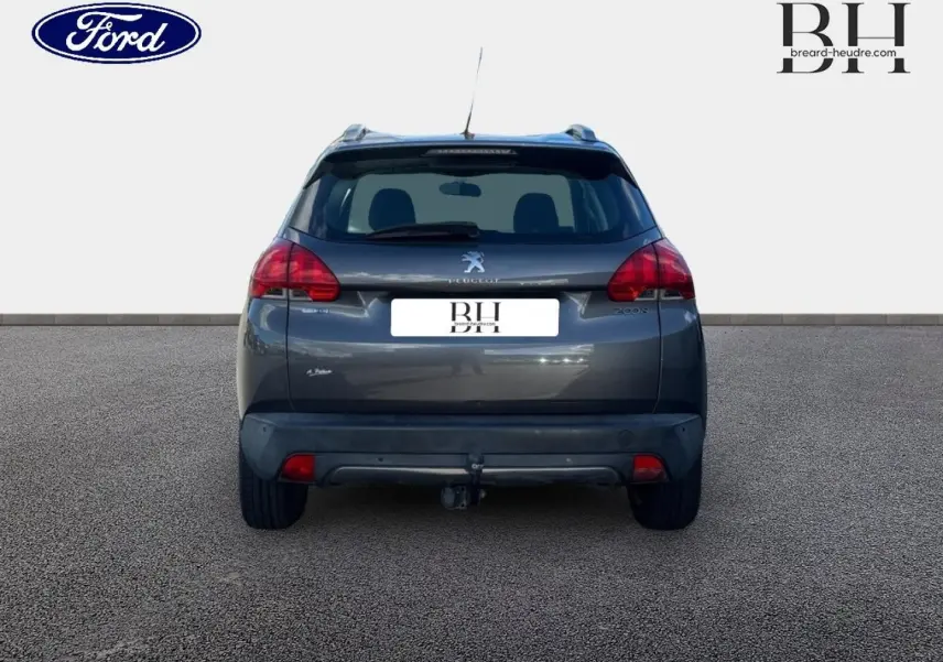 Vue arrière d’un Peugeot 2008 gris Spirit avec attelage, feux arrière rouges et toit noir.