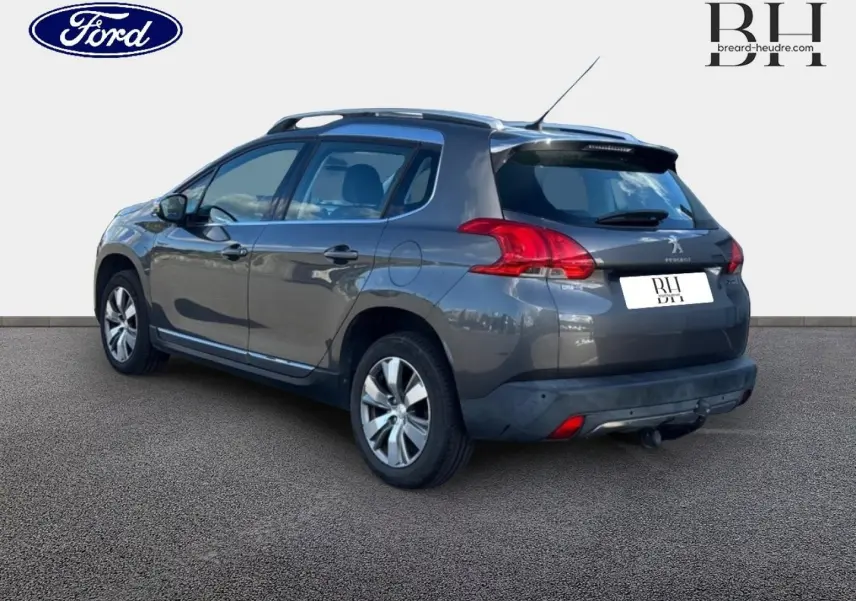 Peugeot 2008 Spirit Grey vue 3/4 arrière droit, avec barres de toit et jantes alu visibles.