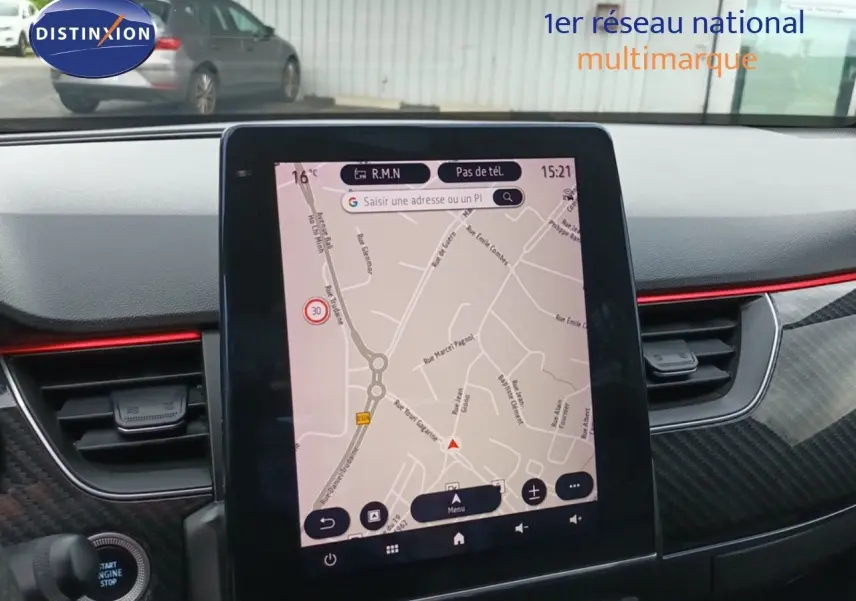Écran tactile central affichant la navigation GPS dans l'habitacle du Renault Arkana noir, avec détails carbone et bande rouge.
