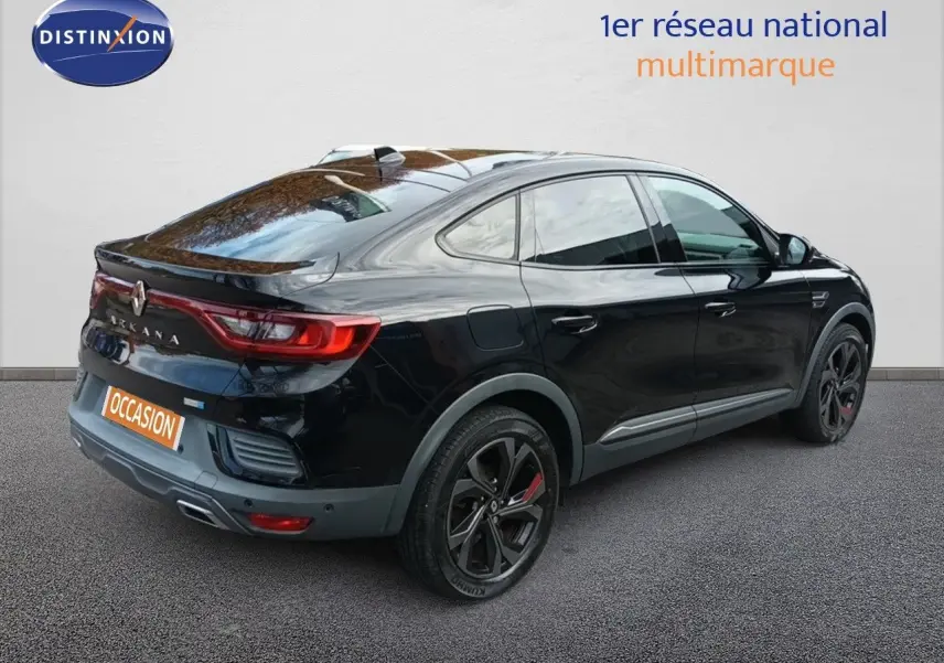 Vue 3/4 arrière droite d'un Renault Arkana noir 2021 RS Line avec jantes noires et feux arrière allumés.