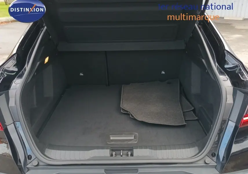 Coffre ouvert vu de l'arrière d'un Renault Arkana noir 2021, avec tapis de sol gris à l'intérieur.