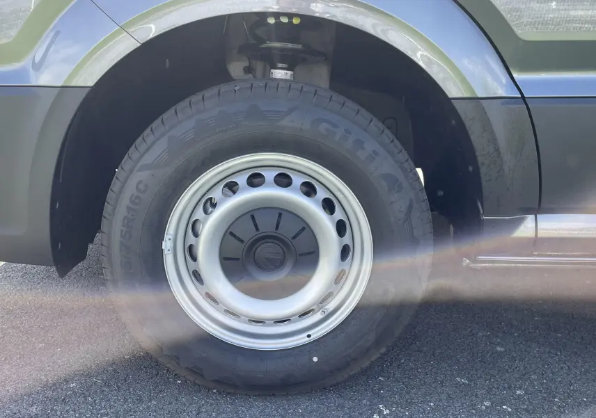 Gros plan sur la roue avant gauche du Volkswagen Crafter Van gris Indium, avec jante acier et pneu Giti.