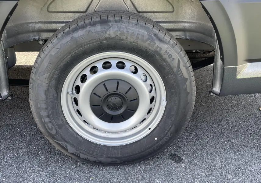 Gros plan sur la roue arrière droite du Volkswagen Crafter Van gris Indium, mettant en valeur la jante acier et le pneu Giti.