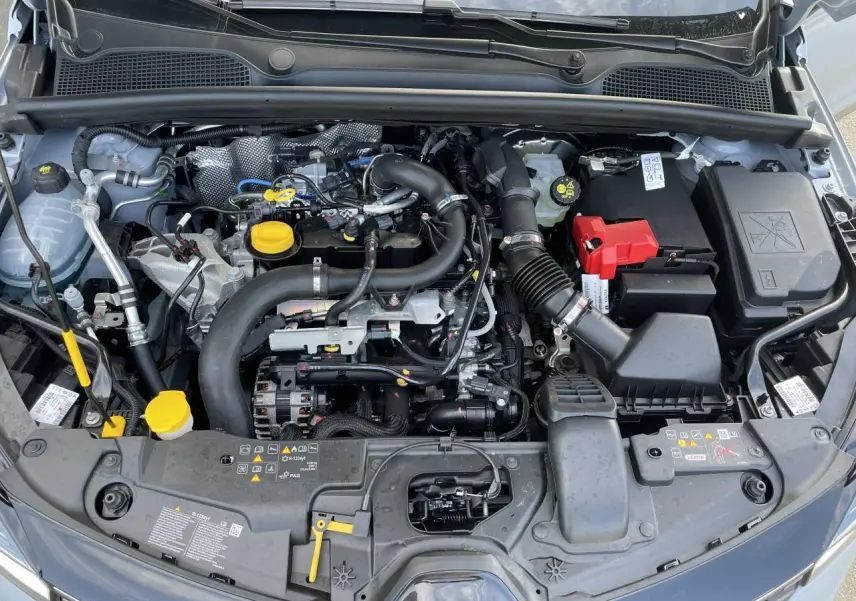 Vue plongeante sur le moteur essence d'une Renault Clio Gris Rafale avec détails des composants sous le capot.