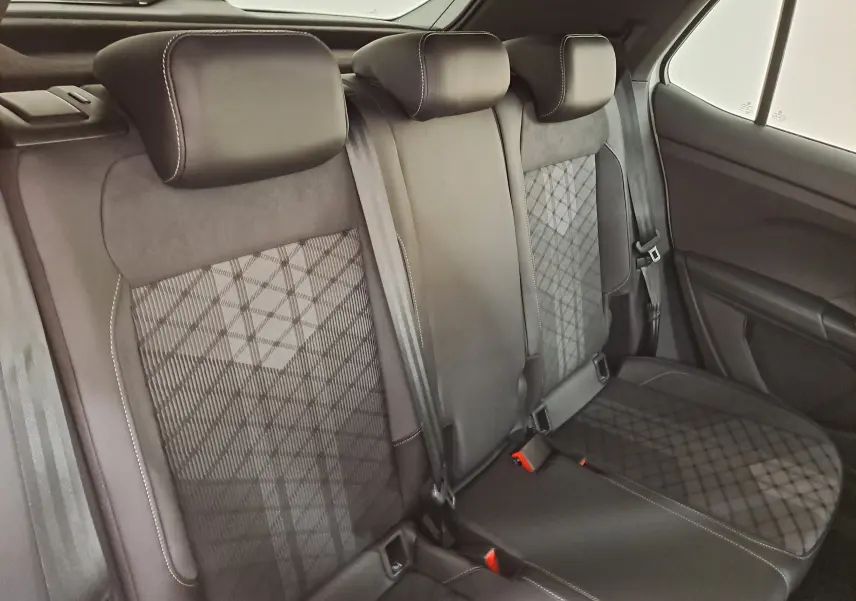 Vue intérieure des sièges arrière noirs avec surpiqûres blanches du Volkswagen T-Cross 1.0 TSI R-Line Edition 2025.