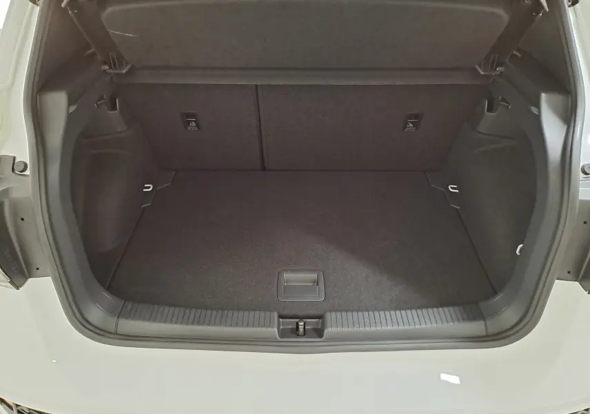 Coffre ouvert vu de l'arrière d'un Volkswagen T-Cross blanc pur 2025, version R-Line Edition, montrant l'espace de chargement vide.