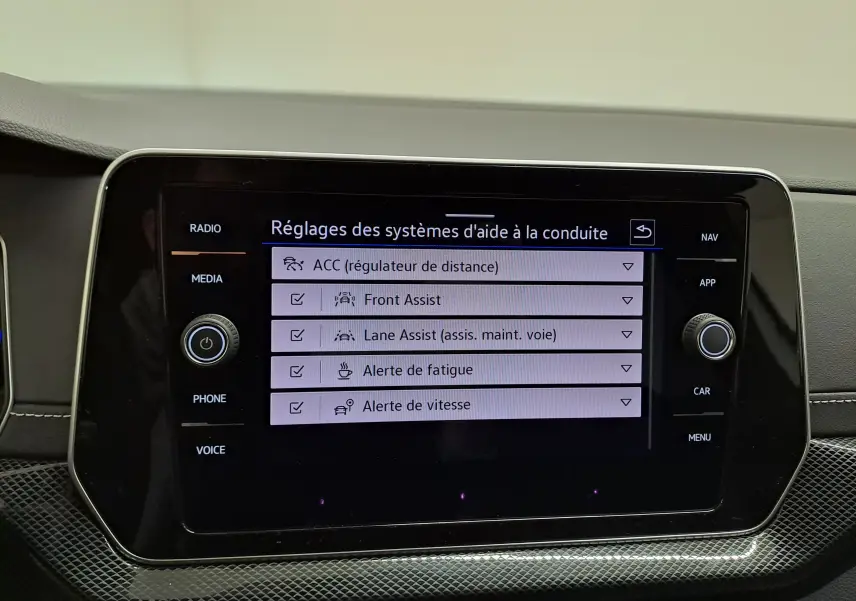 Écran tactile central du Volkswagen T-Cross 2025 blanc, affichant les réglages des aides à la conduite.