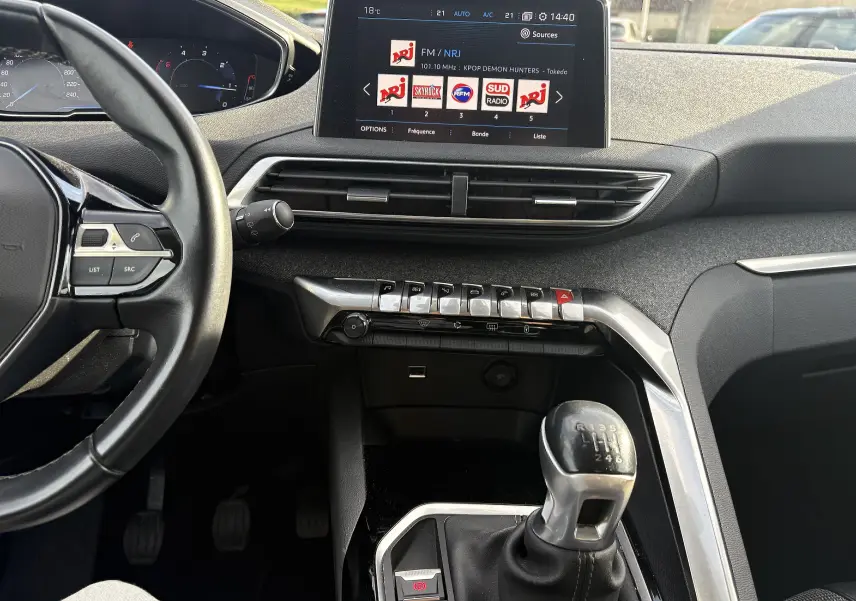 Vue intérieure centrée sur la console et le levier de vitesses manuel du Peugeot 3008 II avec écran tactile et commandes piano.